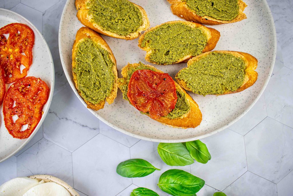 Brusketos su pesto, pomidorais ir mocarela. Pomidoras ant duonos