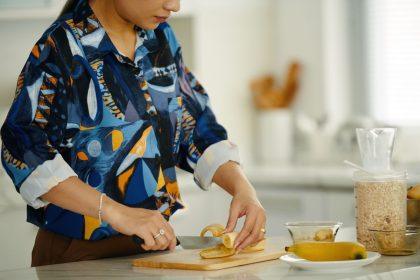 Moteris pjausto bananą ruošiant pusryčius pagal japonijos rytinę dietą