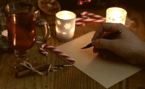 Kalėdinis atvirukas su žvake ir šventinėmis dekoracijomis