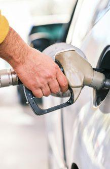a man pumping gas into his car at a gas station