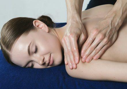 a woman getting a back massage at a spa